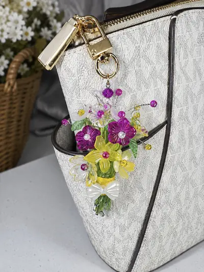 Fuchsia Sunbeam Charm — clipped to a cream handbag