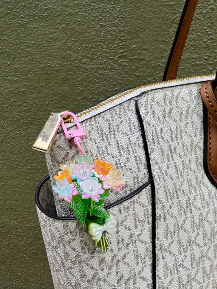 Carnival Bloom Charm clipped to a tote bag