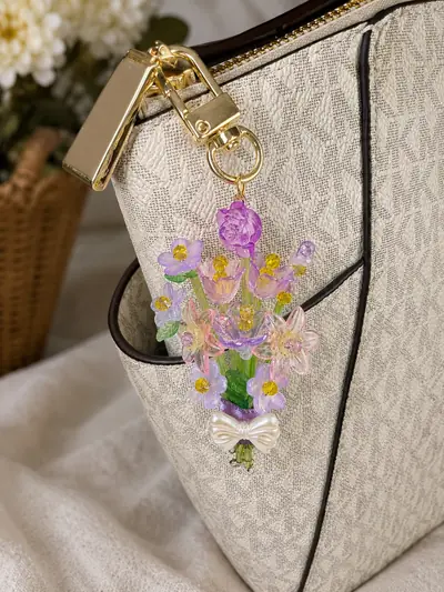 Wisteria Bloom Charm — clipped to a cream handbag